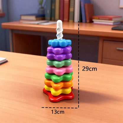 Rainbow rotating stacking tower toy with colorful discs on a white pole base on a table