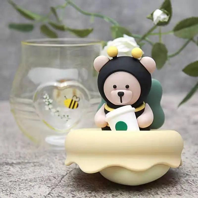 Glass tea infuser mug featuring a bear topper with green cap and honey-yellow lid