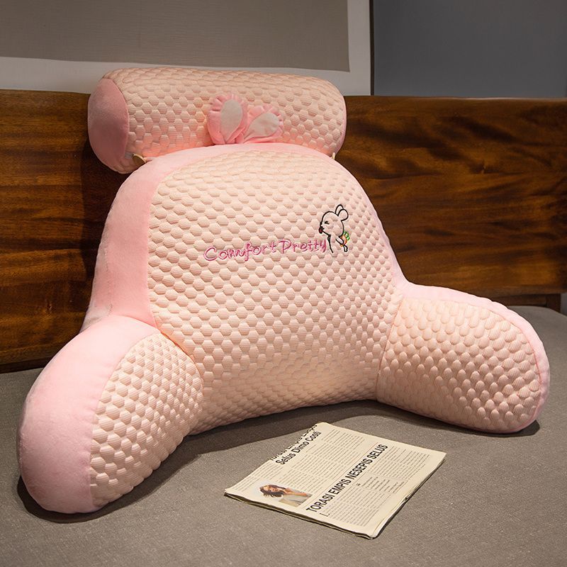 Pink textured plush rabbit reading pillow with raised ears and small bow detail