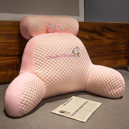 Pink textured plush rabbit reading pillow with raised ears and small bow detail