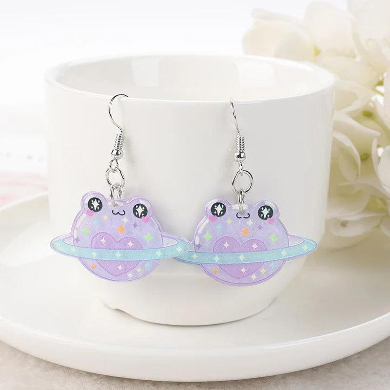 Frog acrylic earrings with purple frog charms, star dots, planet-like shape, and silver hooks