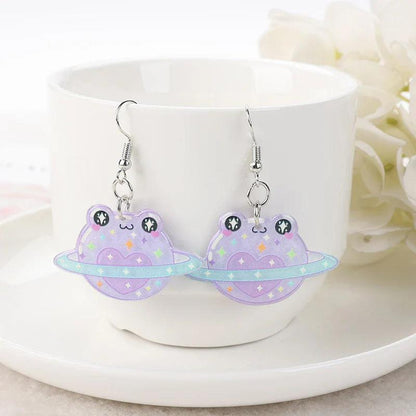 Frog acrylic earrings with purple frog charms, star dots, planet-like shape, and silver hooks