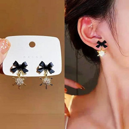Ornament earrings with black bow and gold snowflake charms, with dangling drops