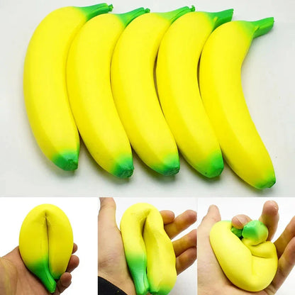Jumbo squishy banana toy in yellow with green ends, shown in a small hand