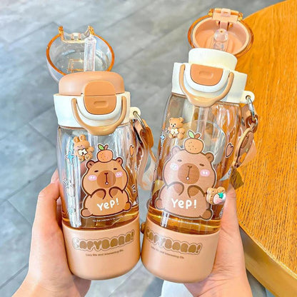 Capybara-themed water bottles in hands, clear body, white cap with orange latch, cute bear face