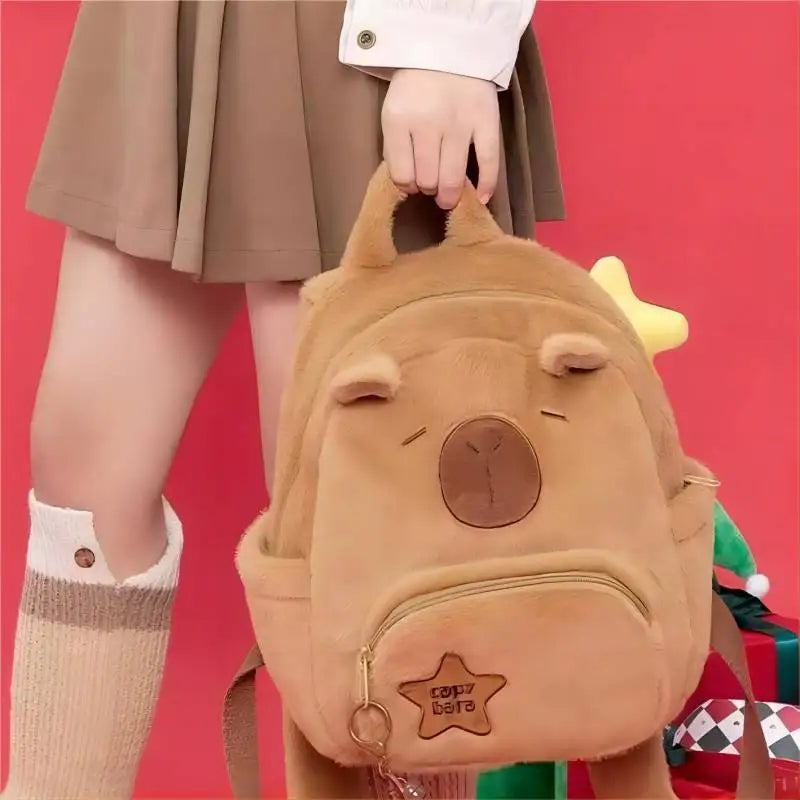 Tan capybara plush backpack with front zip pocket, closed eyes, and top handle
