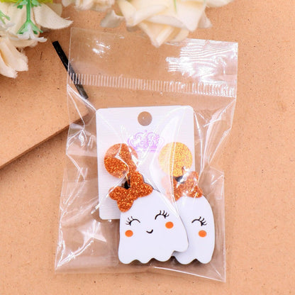 Pair of Halloween ghost face earrings on card, glitter orange crown and bow with white drops