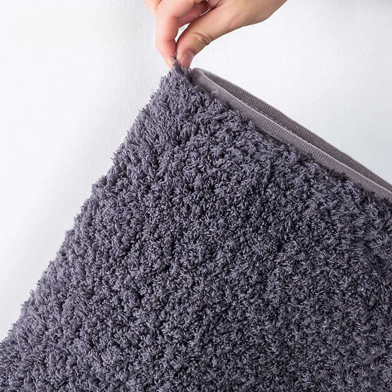 Long-pile absorbent bathroom mat corner close-up with dense shag texture