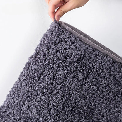 Long-pile absorbent bathroom mat corner close-up with dense shag texture