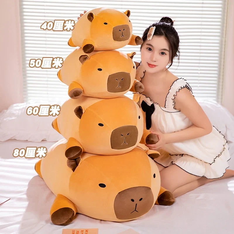 Tall stack of orange capybara plush pillows with brown muzzles