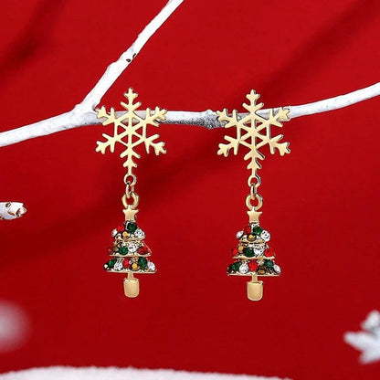 Drop earrings with two gold snowflake charms and small decorated Christmas tree dangles