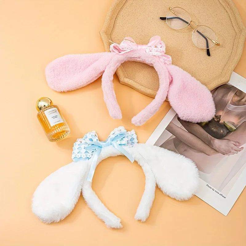 Plush bunny ear headband with pink ears, white band, and light blue lace bow.