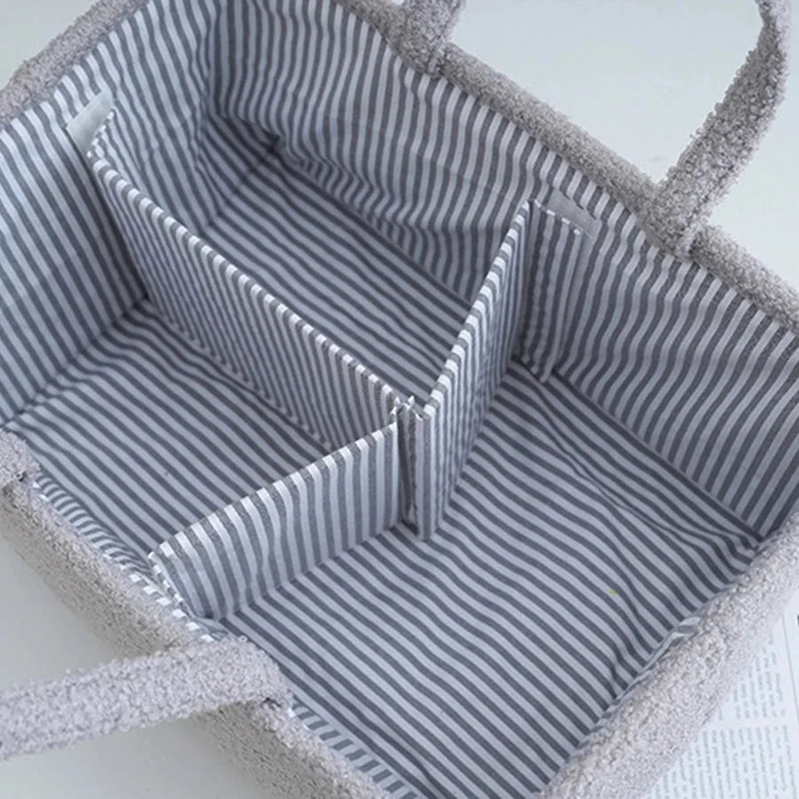 Gray diaper caddy organizer bag interior with striped fabric lining and divider panels