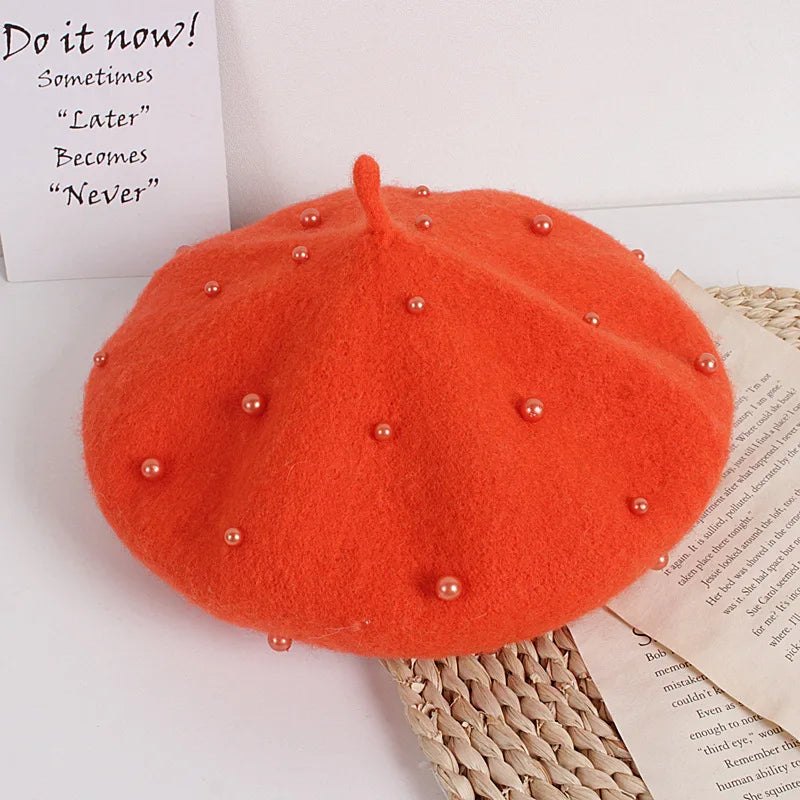 Orange-red felt beret with faux pearl embellishments and a small center stem