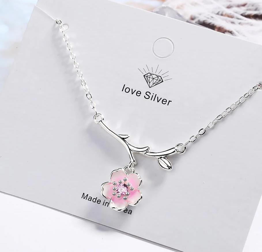 Silver cherry blossom pendant necklace with pink flower charm and curved branch accents