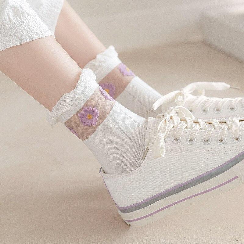 White socks with small purple flower print, worn with white sneaker shoes