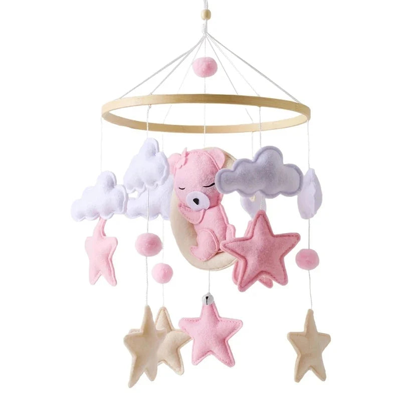 Baby crib mobile with pink bear, gray clouds, and star ornaments