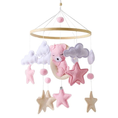 Baby crib mobile with pink bear, gray clouds, and star ornaments
