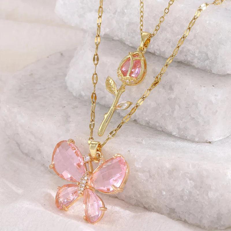 Gold-tone butterfly rose necklace with pink crystal flower pendant and teardrop charm