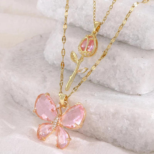 Gold-tone butterfly rose necklace with pink crystal flower pendant and teardrop charm