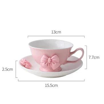 Tea cup and saucer dimensions diagram: white cup with pink bow, 13cm by 15.5cm