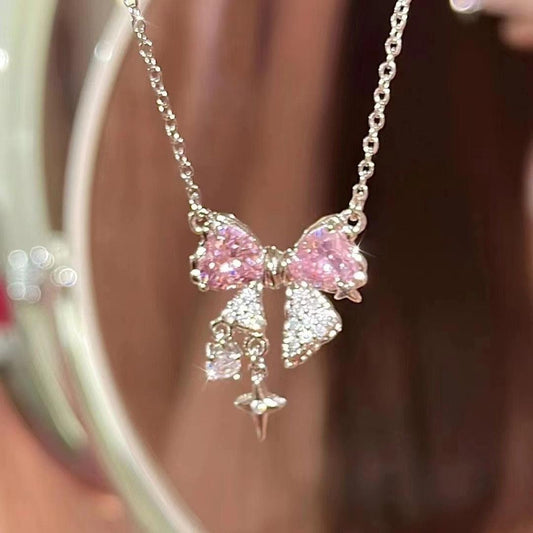 Bow pendant necklace with pink rhinestone bows and dangling star charm