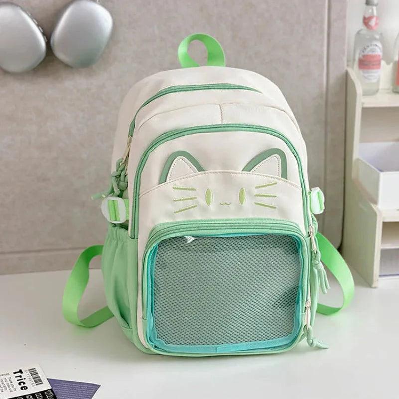 White cat school backpack with green trim, mesh front pocket, and dangling charm details.