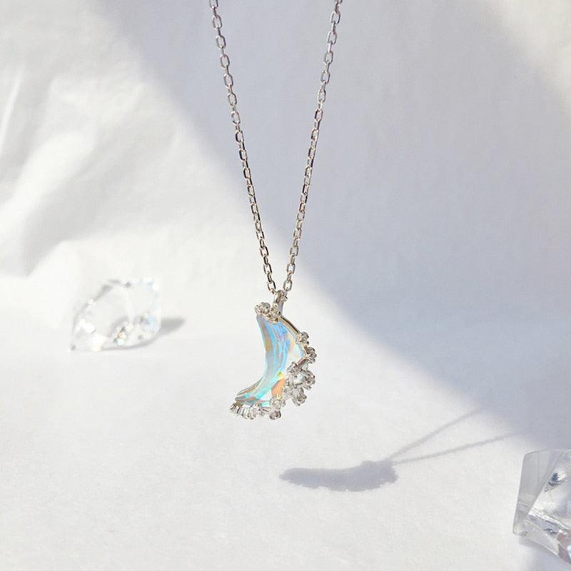 Glazed crescent moon pendant necklace with blue iridescent stone and crystal accents