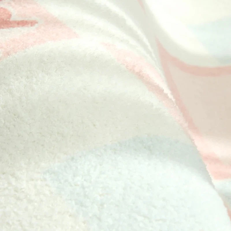 Pastel striped plush rug pile close-up with light blue and pink tones.