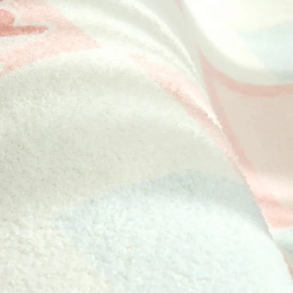 Pastel striped plush rug pile close-up with light blue and pink tones.