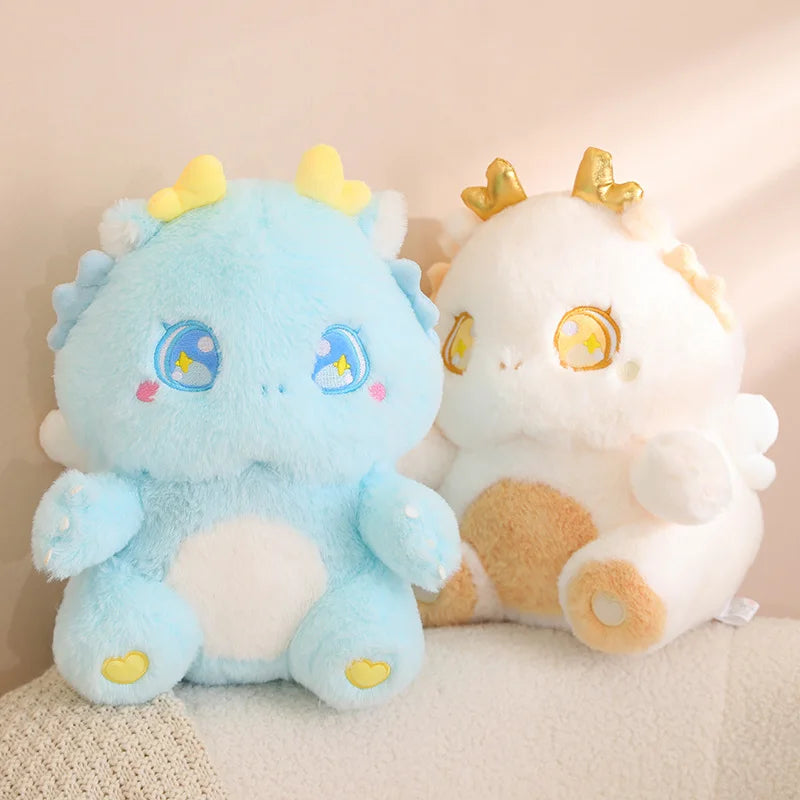 Light blue and white baby dragon plushies with star-eye embroidery and yellow horn tips
