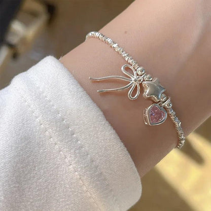 Silver rhinestone bracelet with star and bow charms plus pink heart stone centerpiece