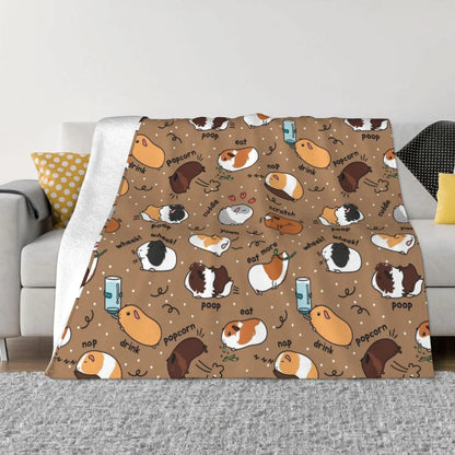 Brown guinea pig throw blanket with playful small pet faces pattern, folded over sofa