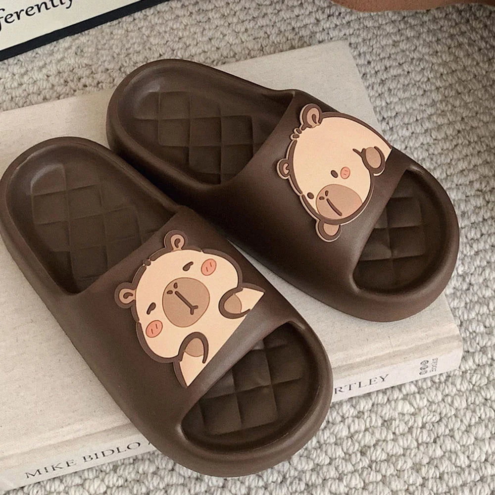 Dark brown capybara slide sandals with beige cartoon face patch on strap.