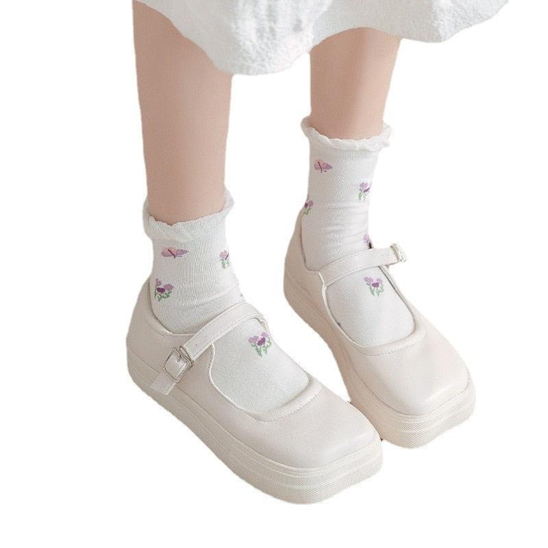 White socks with small purple flower print, worn with white shoes