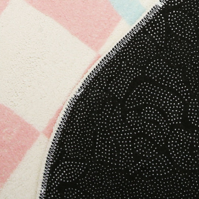 Close-up of rug backing with black speckled texture and stitched edge
