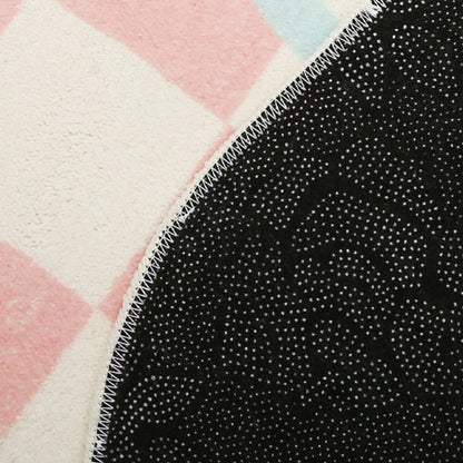 Close-up of rug backing with black speckled texture and stitched edge
