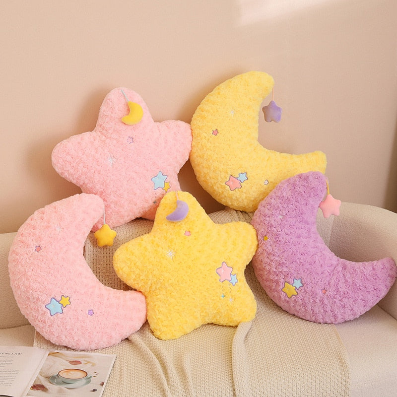 Assorted moon and star plush pillows in pink, yellow, and purple with star patches