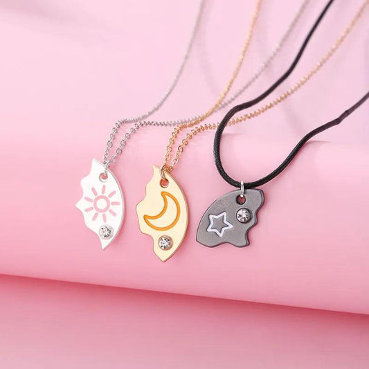 Three moon-and-sun pendant necklaces with black, silver, and gold chain straps