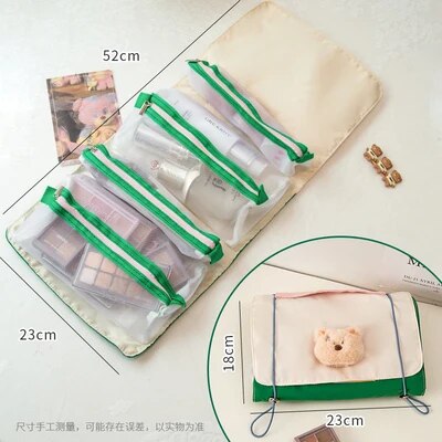 Roll-up travel makeup bag with four clear zip pouches and small teddy patch, green-trimmed cream