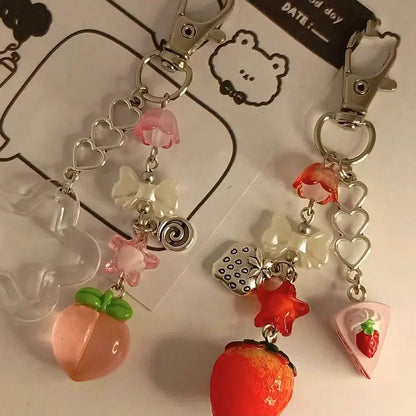 Kawaii fruit keychains with red strawberry, pink peach, hearts, and flower charms