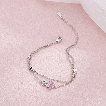 Silver charm bracelet with pink flower pendant and dangling chain with clasp