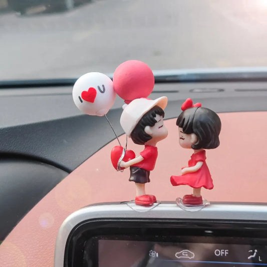 Car dashboard couple ornament figurine, couple standing beside heart balloon decorations