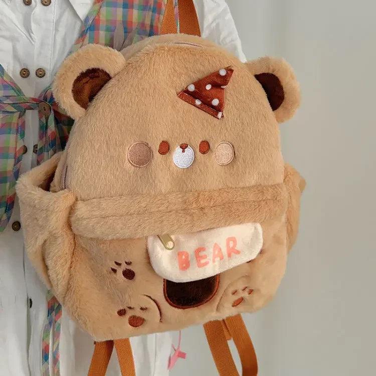 Plush bear backpack with bow, faux-hanging name patch, and small face appliques
