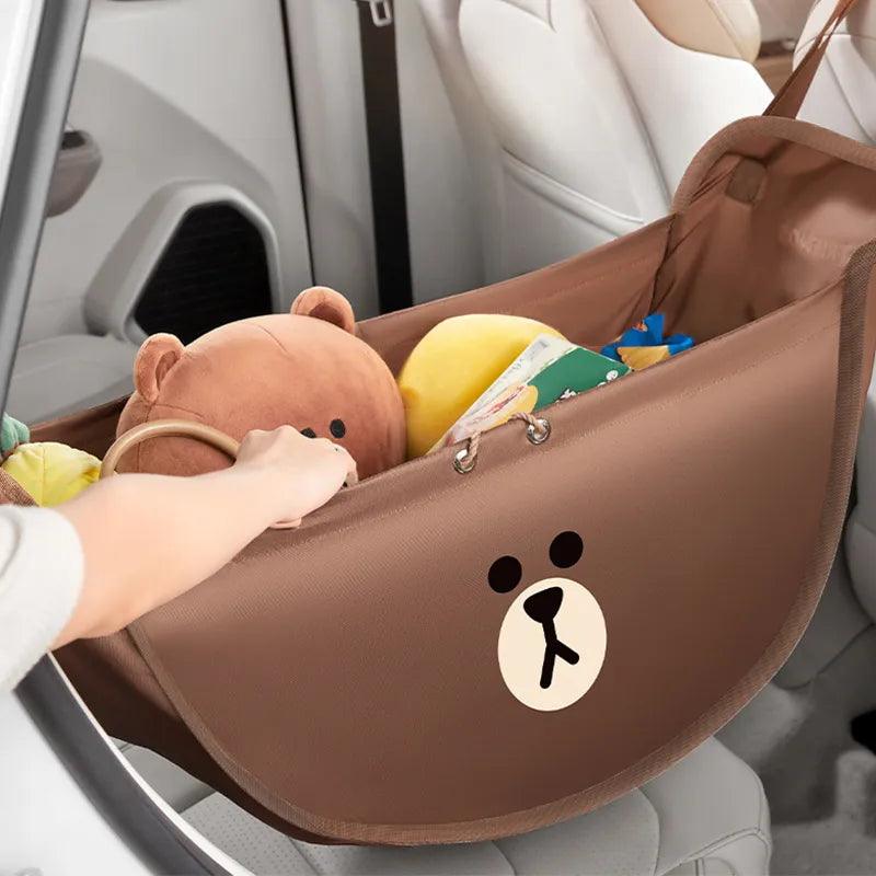 Brown car seat storage hammock with bear emblem and plush toys inside