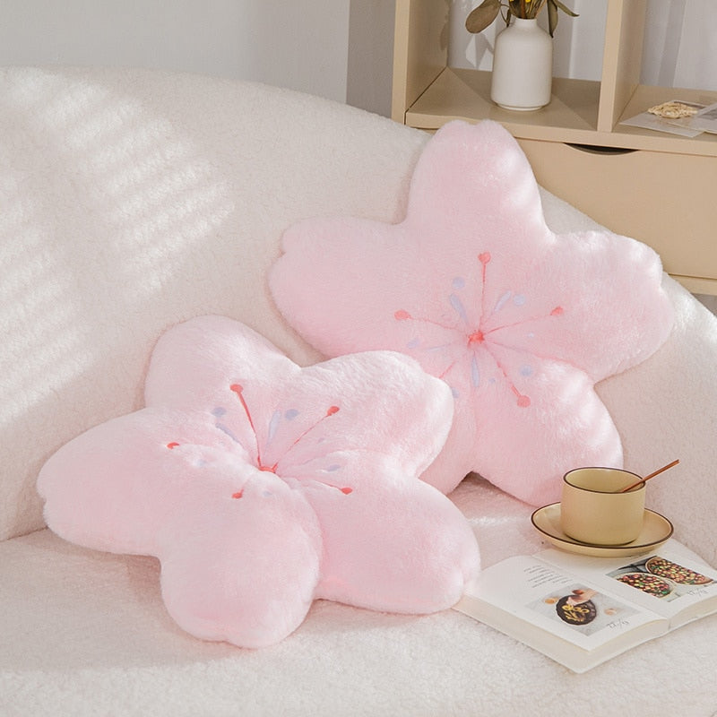 Pink plush cherry blossom pillow with stitched blossom centers and petal-like shape.