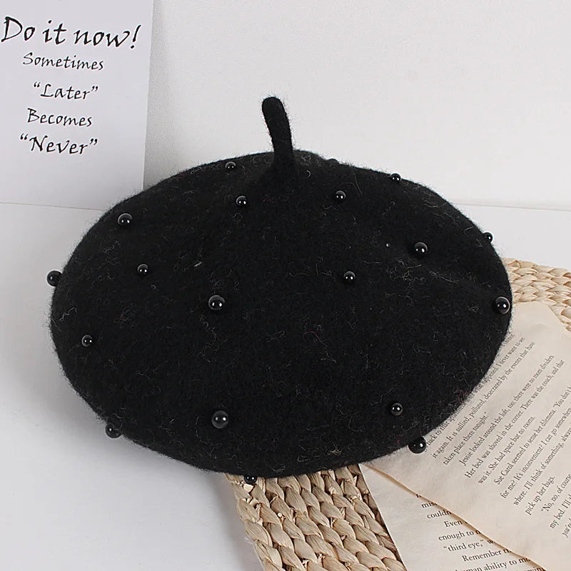 Black felt beret with faux pearl embellishments and tall pointed crown