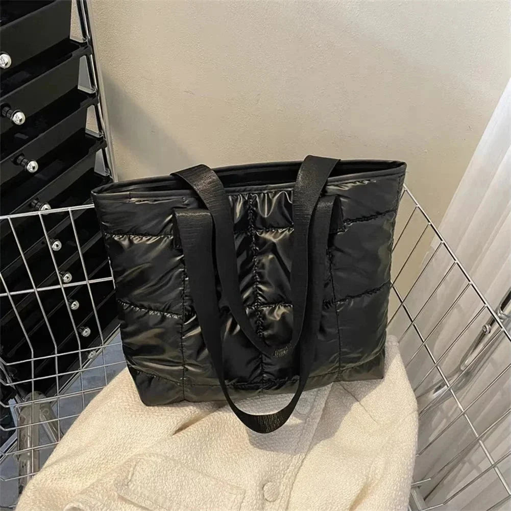 Black quilted tote bag with long handles, open top, quilted puffed design