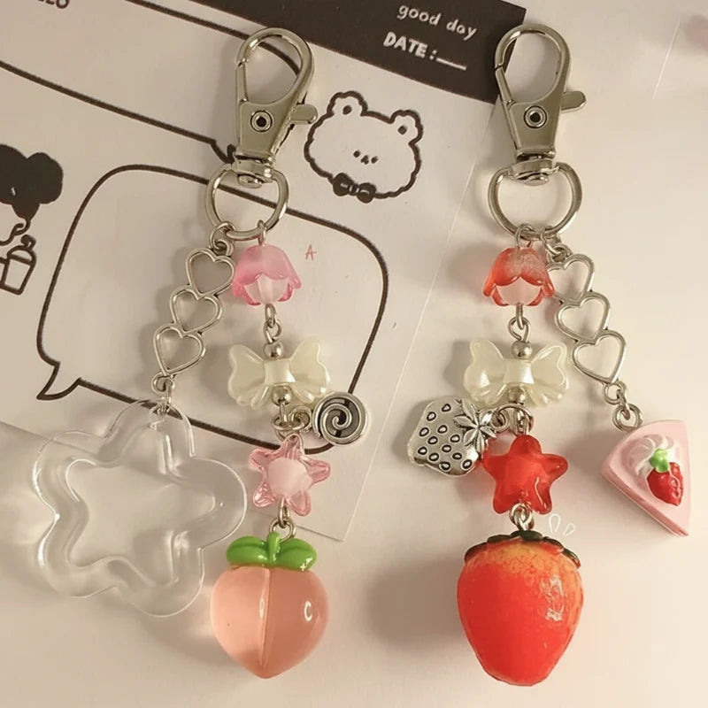 Kawaii fruit keychains with red strawberry and pink peach charms, hearts, and flowers