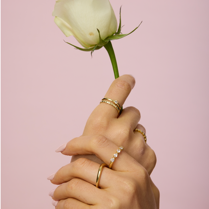 Gold wavy dome ring on finger, polished raised wavy top